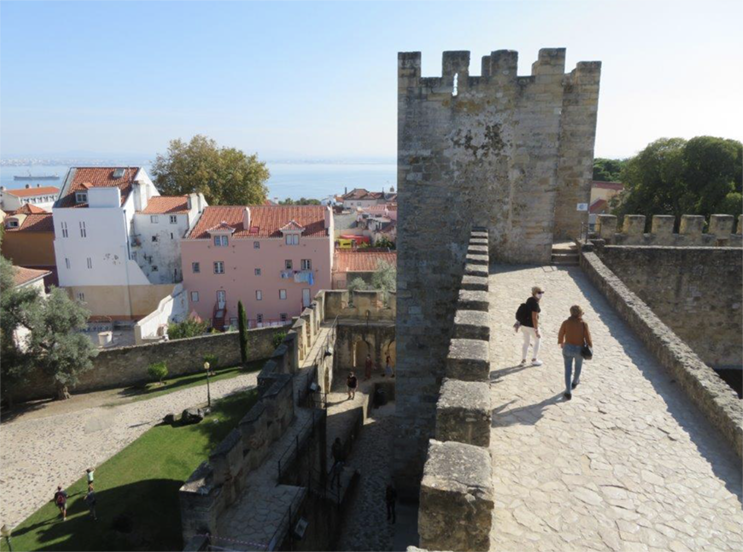 O Castelo de São Jorge tem origem no século XI, mas foi reconstruído em meados do século XX. Perto, na base da colina, fica a Praça Martim Moniz, espaço de reunião de muitos migrantes que habitam a zona.