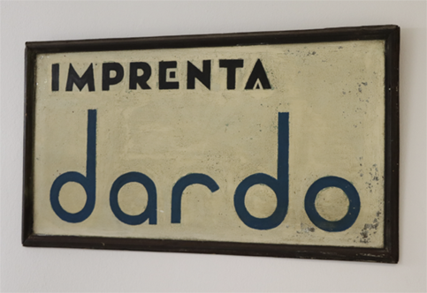 El cartel en la entrada de la imprenta en la época en la que la Falange, después de incautar Imprenta Sur, le impone el nombre de Dardo.
